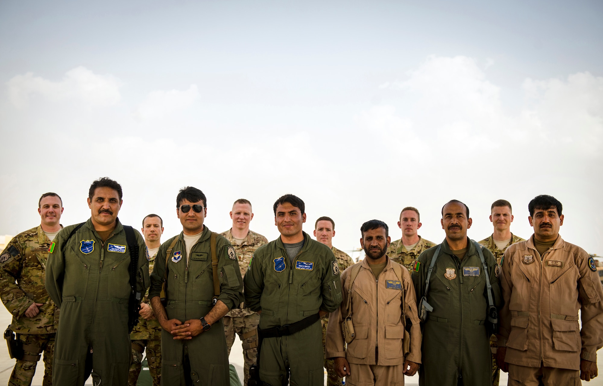 Afghan Air Force aircrew and NATO Air Training Command-Afghanistan air advisors stand together after the first-ever all Afghan C-130 flight, Kabul, Afghanistan, June 16, 2014. As part of NATO Air Training Command-Afghanistan, the advisors are responsible for training and assisting the Afghan pilots and maintainers. The mission of NATC-A is to set the conditions for a professional, fully independent and operationally-capable Afghan Air Force that meets the security requirements of Afghanistan today and tomorrow. The first all-Afghan C-130 flight was accomplished eight months earlier than projected. (U.S. Air Force photo by Staff Sgt. Vernon Young Jr.)