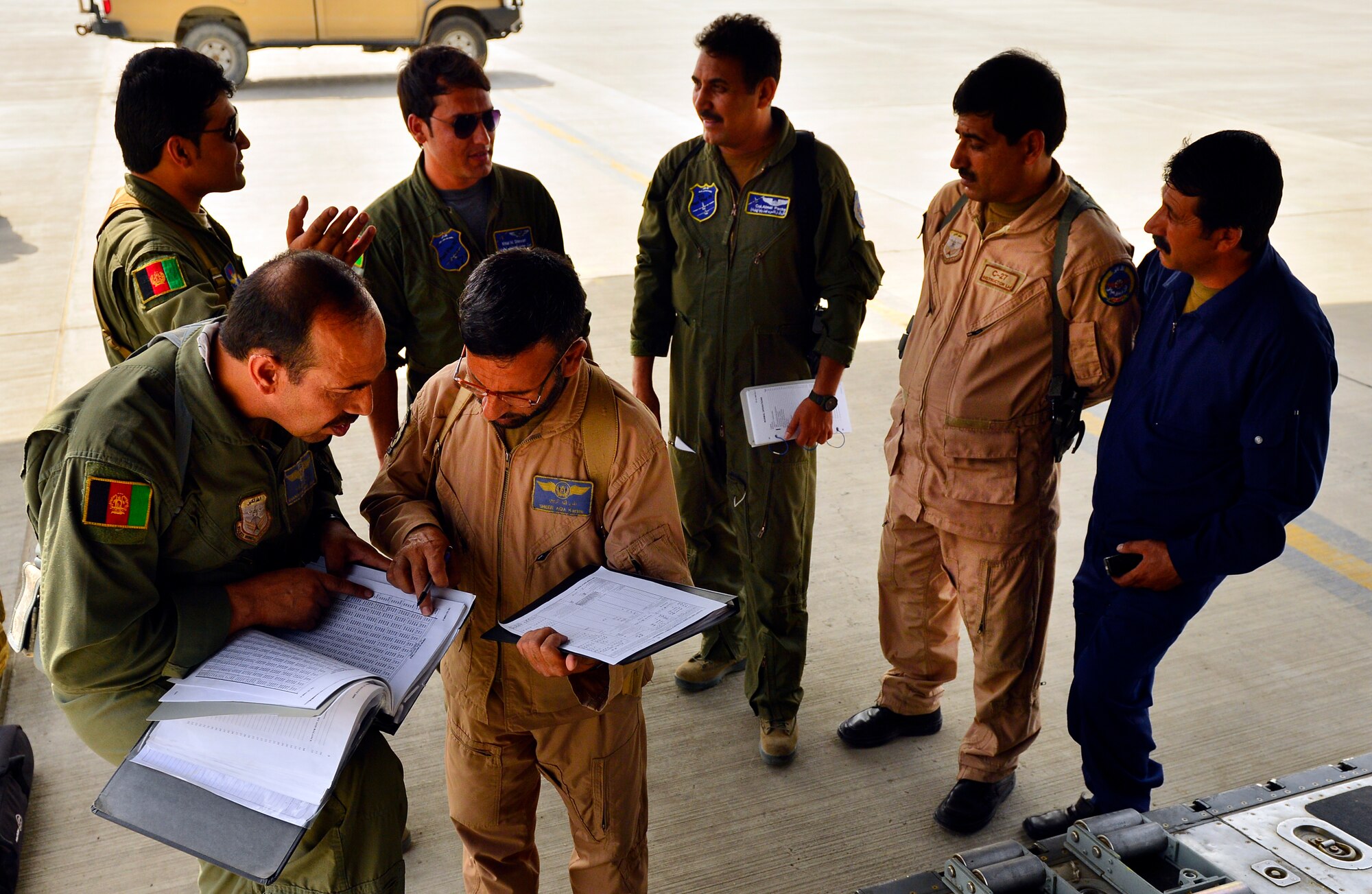 Afghan Air Force aircew have a final meeting during pre-flight inspection as loadmasters discuss load plans prior to the first-ever all Afghan C-130 flight, Kabul, Afghanistan, June 16, 2014. The aircrew, made up of six Afghan Air Force pilots and loadmasters, successfully completed a mission from Kabul to Kandahar and back. The aircrew successfully planned, executed and accounted for movement of about 120 Afghan personnel, two casualty evacuation patients, luggage and cargo in both directions. The ability for the AAF aircrew to move Afghan National Army Security Forces personnel, cargo, CASEVAC patients and human remains missions is a major accomplishment for both the AAF and NATO Air Training Command – Afghanistan advisors assigned to the 438th Air Expeditionary Wing. This milestone was accomplished eight months earlier than projected. (U.S. Air Force photo by Staff Sgt. Vernon Young Jr.)