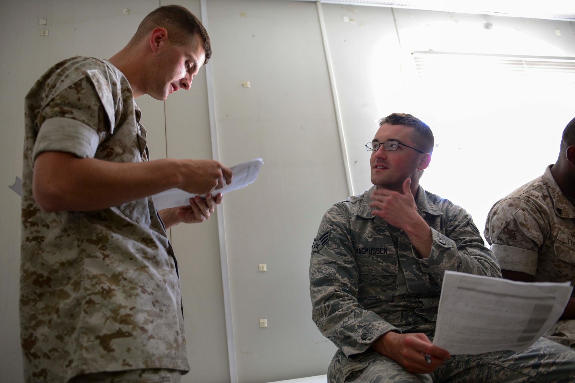 U.S. Marine Corps Cpl. Alex Spangler, Marine Tactical Electronic Warfare Squadron counter measures, and U.S. Air Force Senior Airman Benjamin Rasmussen, 379th Expeditionary Civil Engineer Squadron engineering assistant, give peer feedbacks at Al Udeid Air Base, Qatar, June 16, 2014. The Service members gave each other feedback during a USMC Corporal’s Course, a leadership and development course designed for corporals but was open to other branches of the military deployed here. Spangler is deployed from Cherry Point Marine Corps Air Station, North Caroline and hails from Ewing, Nebraska. Rasmussen is deployed from Yokota Air Base, Japan and is from Dallas.  (U.S. Air Force photo by Staff Sgt. Ciara Wymbs)  