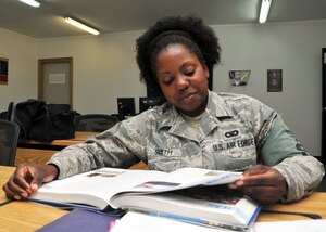 Air Force Staff Sgt. Chandra Smith reviews a book at the 380th Air Expeditionary Wing’s learning resource center at an undisclosed location in Southwest Asia June 4, 2014. (U.S. Air Force photo by Senior Master Sgt. Eric Peterson/Released)