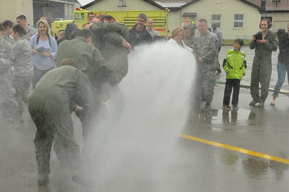 Pilots from the 13th and 14th Fighter Squadron carry U.S. Air Force Col. Matthew Dana, 35 FW vice commander, into the line of fire after his fini-flight, at Misawa Air Base, Japan, June 16, 2014. Carrying on a tradition, family members and friends spray Dana with water after his aviation milestone, his final flight here. (U.S. Air Force photo/ Staff Sgt. Tong Duong)