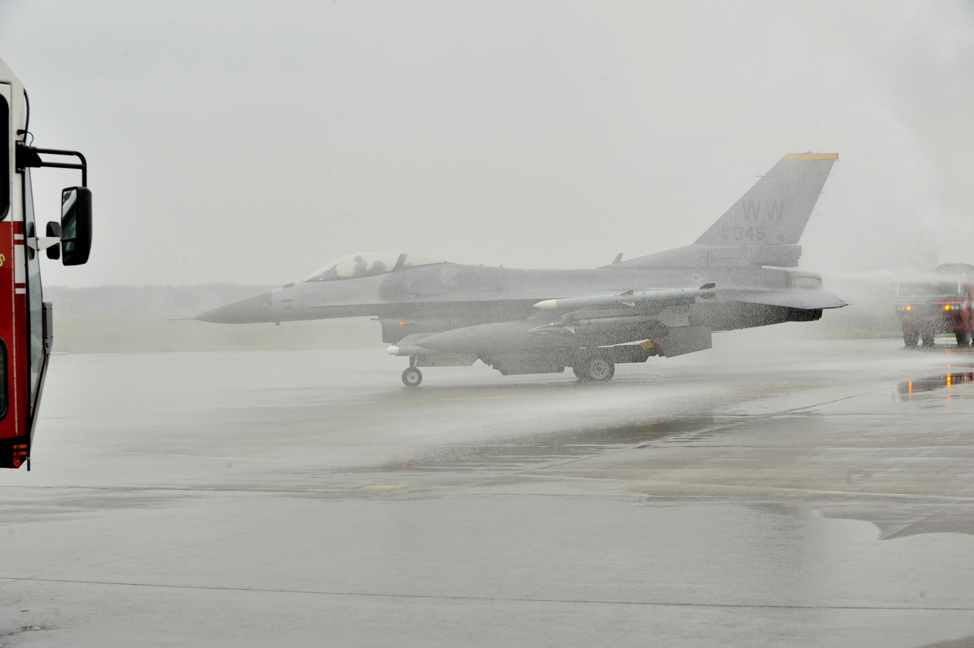 U.S. Air Force Col. Matthew Dana taxis his F-16 Fighting Falcon under an arch of water streaming from 35th Civil Engineer Squadron fire trucks during his fini-flight at Misawa Air Base, Japan, June 16, 2014. Hosing of the aircraft during taxi is a tradition said to have originated during World War II and used to commemorate an aviation milestone.  (U.S. Air Force photo/ Staff Sgt. Tong Duong)