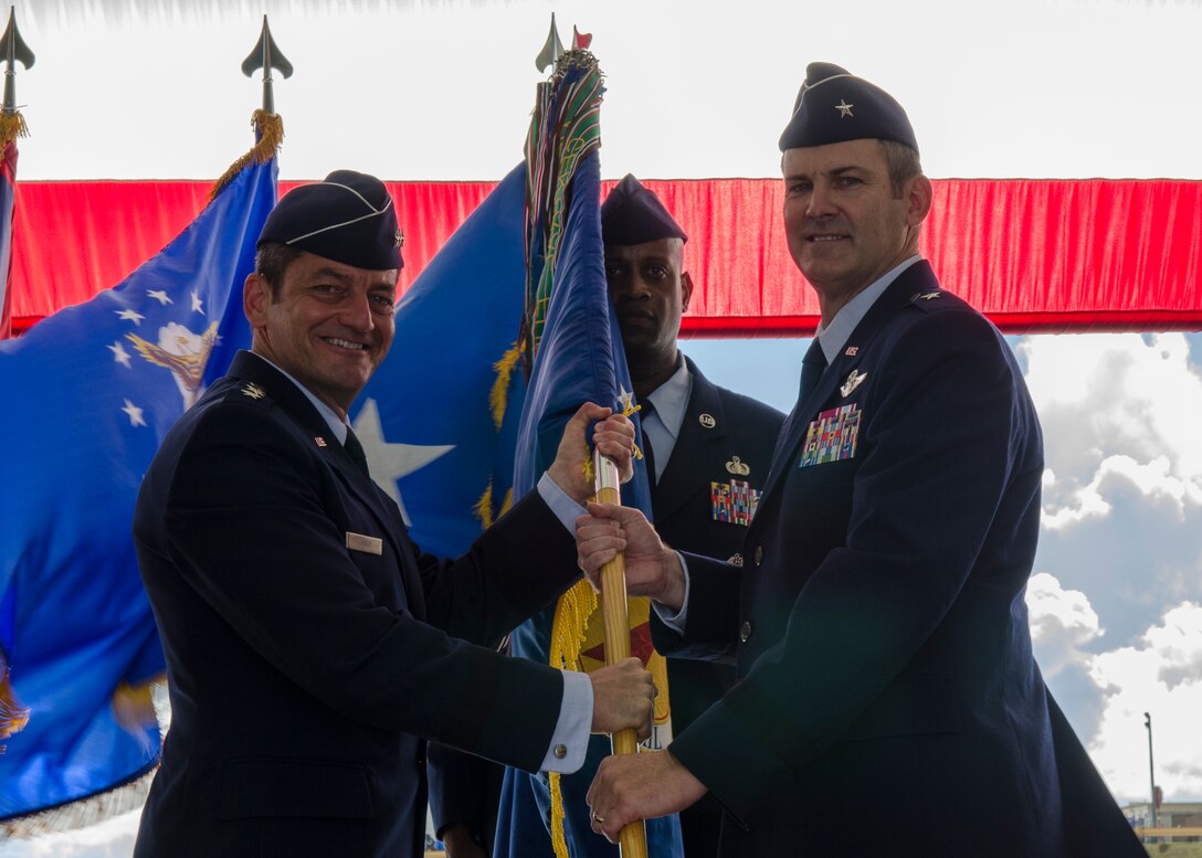 Lt. Gen. Russell Handy (left), 11th Air Force commander, passes the 36th Wing guidon to Brig. Gen. Andrew Toth during the Wing change of command ceremony June 19, 2014, on Andersen Air Force Base, Guam.  The unit guidon serves to identify the unit and is a symbol of the commander's authority and presence. (U.S. Air Force photo by Senior Airman Katrina M. Brisbin/Released)