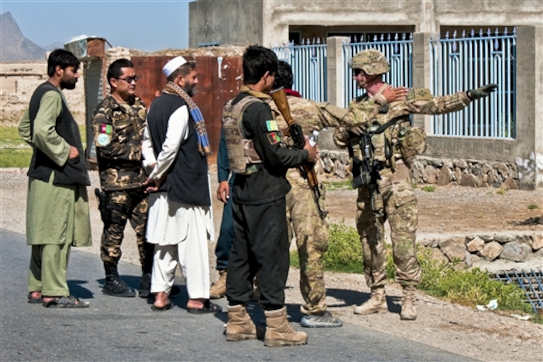 U.S. Army 1st Lt. Timothy Robberstad receives guidance from local elders and leaders from the Afghan defense service outside a polling site in the Dand district of Afghanistan's Kandahar province, June 11, 2014. Robberstad, a platoon leader assigned to the 4th Infantry Division's 1st Platoon, Company B, 1st Battalion, 12th Infantry Regiment, 4th Brigade Combat Team, was part of an Afghan-led effort to clear polling sites to ensure safe elections. 