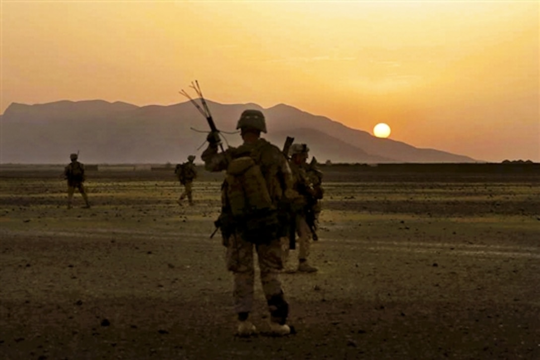 U.S. Marines maneuver into a village during a mission as the sun rises in Helmand province, Afghanistan, June 6, 2014. The Marines are assigned to assigned to Bravo Company, 1st Battalion, 7th Marine Regiment. 