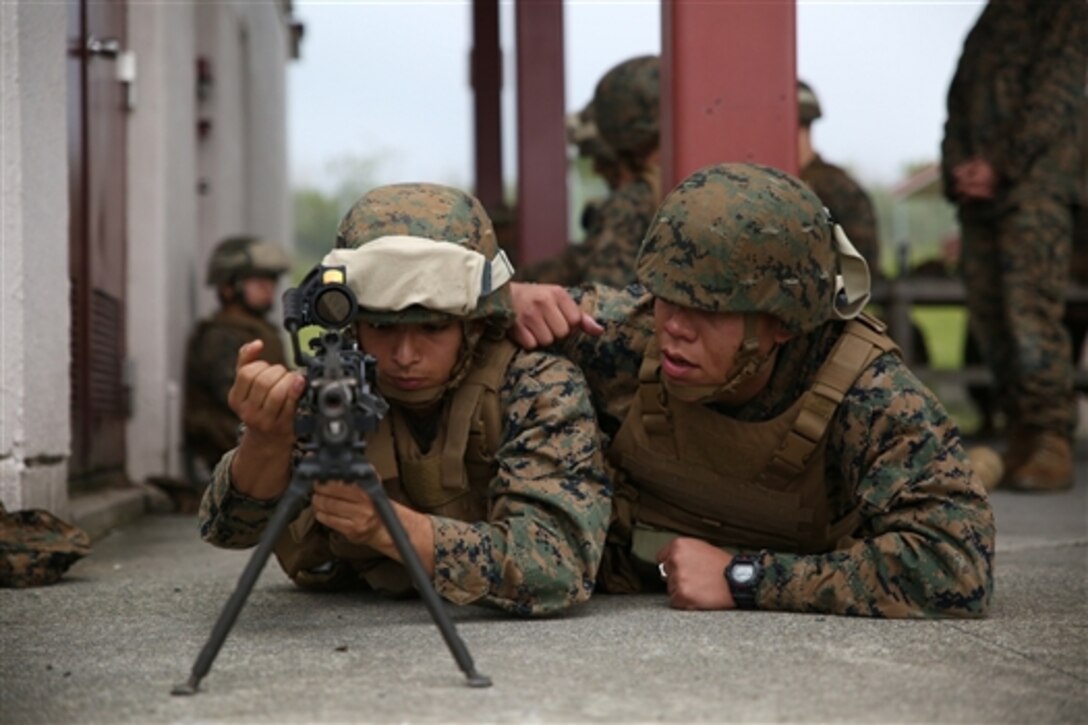 U.S. Marine Corps Pfc. Chris Tabares, left, executes drills with an M249 squad automatic weapon with Pfc. Luis Mejialagos during Fuji Warrior at Combined Arms Training Center Camp Fuji in Shizuoka, Japan, June 8, 2014. During the exercise, Marines and sailors learn to operate numerous weapons. Mejialagos, an administrative specialist, and Tabares, an electrician, are assigned to Combat Logistics Regiment 37, 3rd Marine Logistics Group, 3rd Marine Expeditionary Force. 