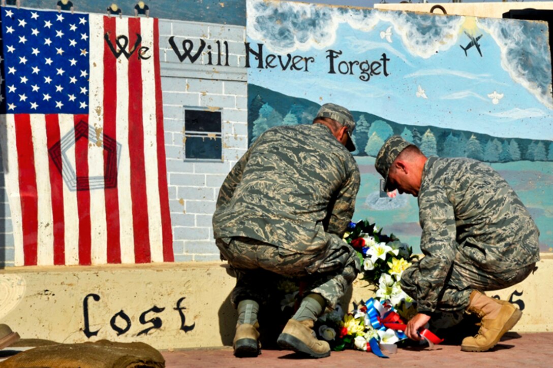 U.S. Air Force Col. Michael P. Zick, and Command Chief Mitchell K. Balutski lay a wreath at the foot of a 9/11 memorial in Southwest Asia, Sept. 11, 2011. Zick is commander of the 386th Air Expeditionary Wing.  
