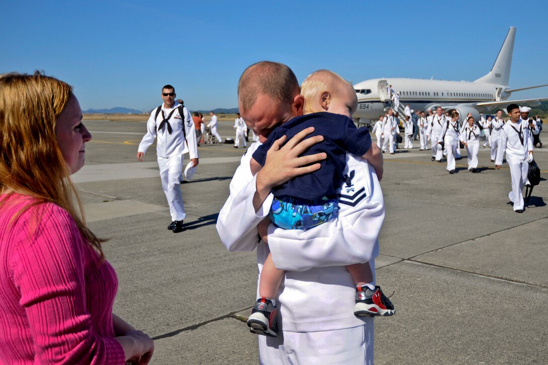 Navy Petty Officer 2nd Class James McDowell hugs his son during a homecoming ceremony on Naval Air Station Whidbey Island in Oak Harbor, Wash., Sept. 9, 2011, following an seven-month deployment aboard the aircraft carrier USS Ronald Reagan. McDowell, a logistics specialist, is assigned to Electronic Attack Squadron 139.  
