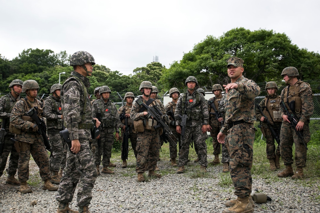 U.S. Marine 1st Lt. Bryce Morgan, third from right, briefs Republic of Korea and U.S. Marines June 11 during military operations on urbanized terrain training at the MOUT training center in Pohang, Republic of Korea. The two-day training evolution covered the basics of patrolling through an urban environment, reacting to enemy contact, crossing danger areas, as well as  clearing out rooms, stairwells and buildings. The U.S. Marines are in Pohang to take part in the Korean Marine Exchange Program 14-8, a combined, small-unit training exercise, which enhances the combat readiness and interoperability of ROK-U.S. Marine Corps forces. Morgan is a military police officer with Company C, 3rd Law Enforcement Battalion, III Marine Expeditionary Force Headquarters Group, III MEF. The U.S. Marines are military policemen with the company. The ROK Marines are military policemen with Military Police Company, 2nd ROK Marine Division. (U.S. Marine Corps photo by Lance Cpl. Drew Tech/Released)