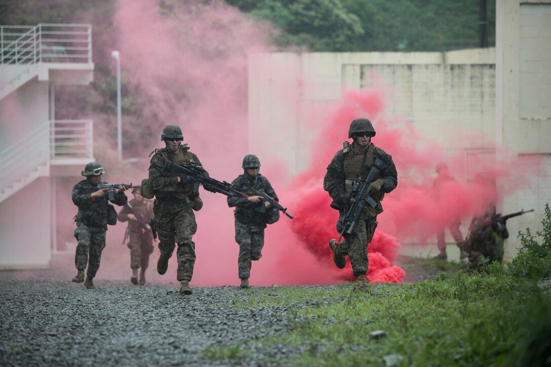 Republic of Korea and U.S. Marines advance through a haze of smoke June 12 during military operations on urbanized terrain training at the MOUT training center in Pohang, Republic of Korea. The two-day training evolution covered the basics of patrolling through an urban environment, reacting to enemy contact, crossing danger areas, as well as  clearing out rooms, stairwells and buildings. The U.S. Marines are in Pohang to take part in the Korean Marine Exchange Program 14-8, a combined, small-unit training exercise, which enhances the combat readiness and interoperability of ROK-U.S. Marine Corps forces. The ROK Marines are military policemen with Military Police Company, 2nd ROK Marine Division. The U.S. Marines are military policemen with Company C, 3rd Law Enforcement Battalion, III Marine Expeditionary Force Headquarters Group, III MEF. (U.S. Marine Corps photo by Lance Cpl. Drew Tech/Released)
