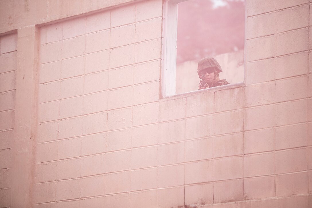 U.S. Marine Lance Cpl. Dominique A. Johnson provides security through a haze of red smoke June 12 during military operations on urbanized terrain training at the MOUT training center in Pohang, Republic of Korea. The two-day training evolution covered the basics of patrolling through an urban environment, reacting to enemy contact, crossing danger areas, as well as  clearing out rooms, stairwells and buildings. The U.S. Marines are in Pohang to take part in the Korean Marine Exchange Program 14-8, a combined, small-unit training exercise, which enhances the combat readiness and interoperability of ROK-U.S. Marine Corps forces. Johnson is a military policeman with Company C, 3rd Law Enforcement Battalion, III Marine Expeditionary Force Headquarters Group, III MEF. (U.S. Marine Corps photo by Lance Cpl. Drew Tech/Released)