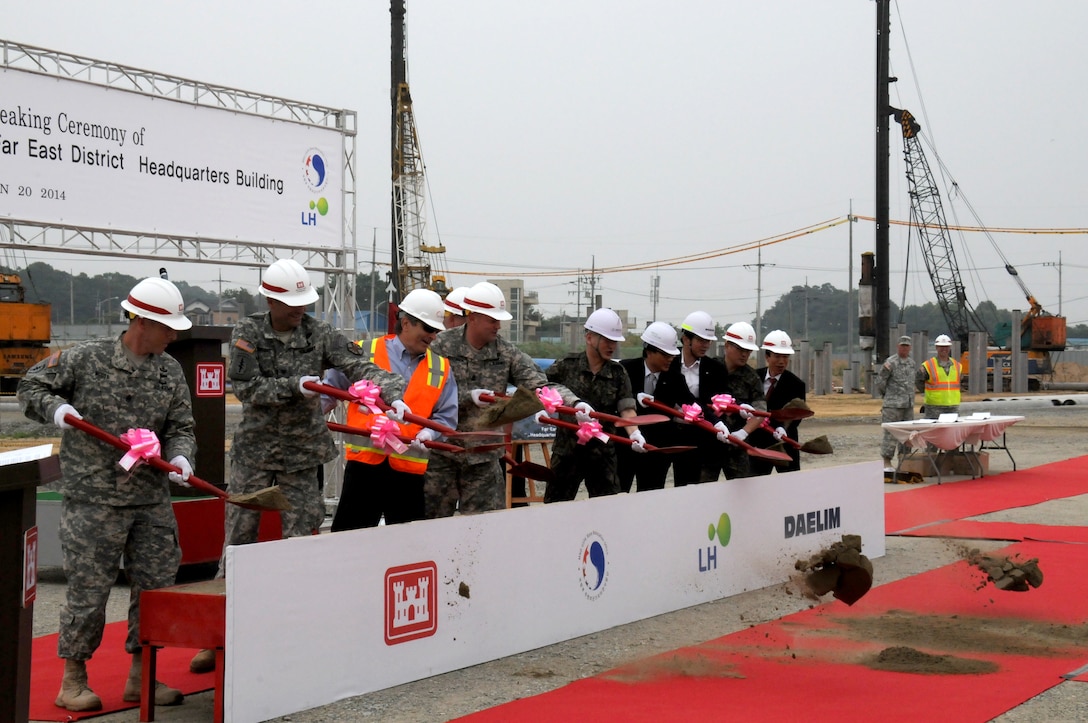 U.S. and Republic of Korea officials toss shovels of dirt during a ceremonial groundbreaking June 20 at U.S. Army Garrison Humphreys.  The officials are breaking ground on the new U.S. Army Corps of Engineers Far East District headquarters.  About 60 district employees, family members, and friends of the district attended the event.  