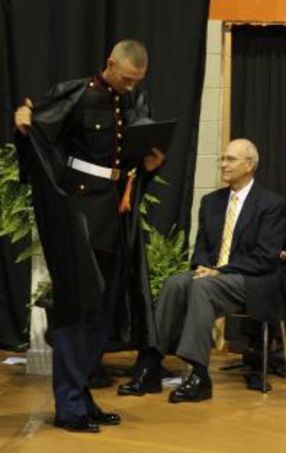 U.S. Marine Corps Pvt. Andrew D. Morris, a Jacksonville, N.C., native and recent  recruit training graduate, removes his cap and gown to reveal his dress blue bravo uniform after receiving his diploma during a graduation ceremony at Southwest High School in Jacksonville, N.C., June 14, 2014. Morris worked tirelessly to finish high school early and walk at graduation after already earning the title of Marine.  (U.S. Marine Corps photo by Sgt. Dwight A. Henderson/Released)

