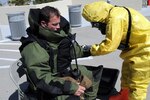 Army Sgt. 1st Class Marcia Hento, from the 82nd Civil Support Team, decontaminates Riley Cook, a member of the South Dakota's Division of Criminal Investigation bomb squad, after he collected samples from a package leaking a hazardous chemical during an emergency response training exercise at Mount Rushmore National Memorial, April 11, 2012. The DCI bomb squad partnered with the South Dakota National Guard's 82nd CST to test equipment and procedures while working together. The CST specializes in chemical, biological and radiological detection and the DCI has expertise with the disposal of explosive ordnances.