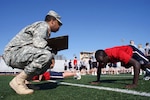 Army Pvt. Paul Baiywo (right) takes his first physical fitness assessment at the Raytown High School track while his recruiter, Army Sgt. Jerry Simons, encourages him to do as many push-ups as he can April 16, 2012.