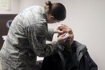 Air Force Senior Airman Keisha Eanes, from Joint Base Elmendorf-Richardson, administers an eye exam at the Alaska National Guard armory in Nome, April 16, 2012. Optometrists have performed 1,697 procedures, assisting 582 patients during Arctic Care 2012.