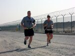 Army Staff Sgt. Samuel Joyce of the 113th Sustainment Brigade runs a few laps with Sgt. 1st Class Rita Rice during her 100-mile run around Camp Arifjan, Kuwait, April 1, 2012. Each lap around the base was approximately seven miles, and Rice dedicated every lap of her race to fallen comrades from North Carolina.