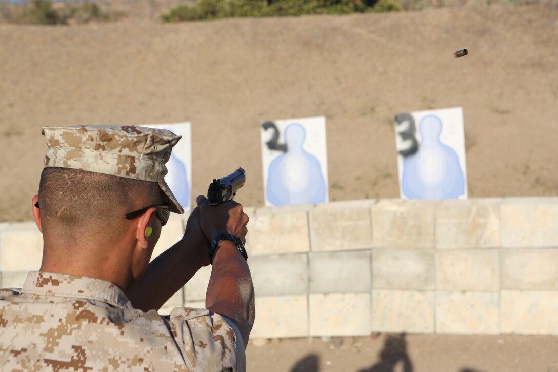 Cpl. Fernado Verdoza, a military police officer with the Marine Corps Air Station Miramar Provost Marshal’s Office, fires an M-9 pistol during a practical weapons course aboard MCAS Miramar, Calif., June 18. The training helped keep Marines and police officers current with annual training requirements.