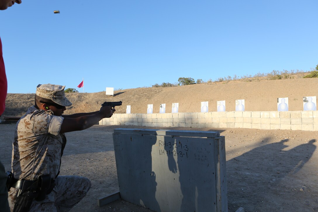 Lance Cpl. Jonathan Vargas-Blanco, a military police officer with the Marine Corps Air Station Miramar Provost Marshal’s Office, fires from behind cover during a practical weapons course aboard MCAS Miramar, Calif., June 18. Military police also conducted a low-light fire range as part of the training.