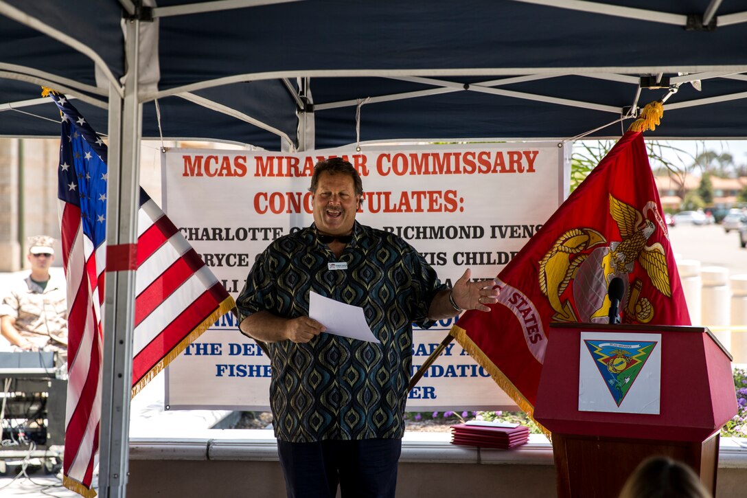 Robert Nagle, Miramar Commissary store director, welcomes families and guests to the Defense Commissary Agency and the Fisher House Foundation Scholarship award ceremony aboard Marine Corps Air Station Miramar, Calif., June 19. The ceremony presented $2,000 scholarships to six high school seniors who submitted contest-winning essays. 
