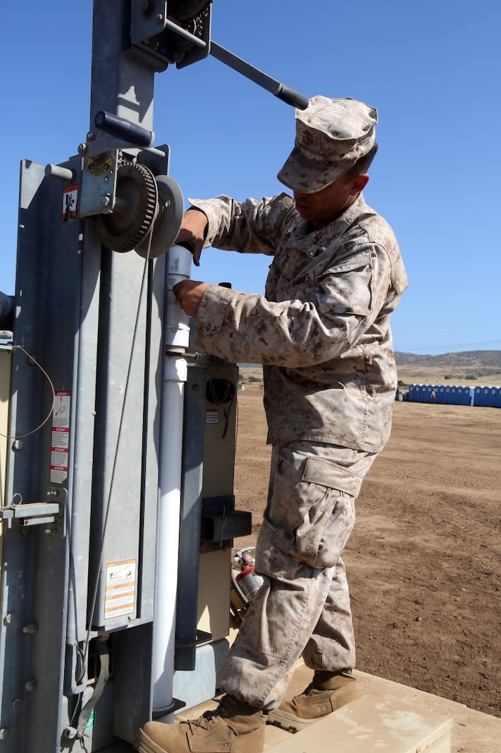 Corporal Allan Lopatinsky, a water support technician with I Marine Expeditionary Force Headquarters Group, adjusts a light during the 2014 I Marine Expeditionary Brigade command post exercise aboard Camp Pendleton, Calif., June 19, 2014. The CPX was designed to help improve the 1st Marine Expeditionary Brigade's readiness for deployment. (U.S. Marine Corps photo by Lance Cpl. David Silvano/released)