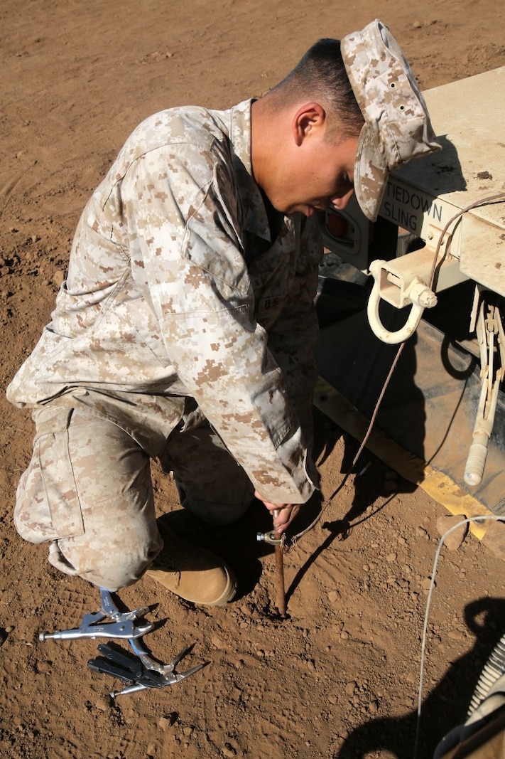 Corporal Allan Lopatinsky, a water support technician with I Marine Expeditionary Force Headquarters Group, adjusts a light during the 2014 I Marine Expeditionary Brigade command post exercise aboard Camp Pendleton, Calif., June 19, 2014. The CPX was designed to help improve the 1st Marine Expeditionary Brigade's readiness for deployment. (U.S. Marine Corps photo by Lance Cpl. David Silvano/released)