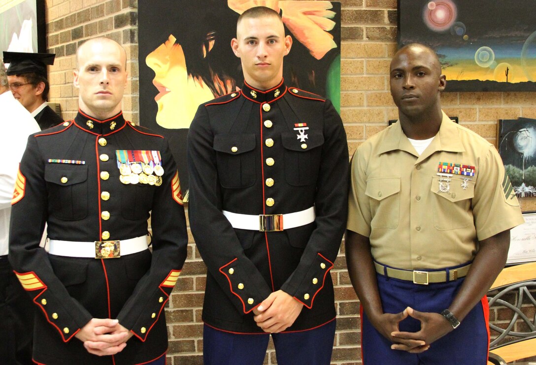 U.S. Marine Corps Pvt. Andrew D. Morris, center, a Jacksonville, N.C., native and recent recruit training graduate, poses for a picture with his recruiter, U.S. Marine Corps Staff Sgt. Christopher L. Hossley, left, the staff noncommissioned officer in charge of Recruiting Sub Station Wilmington, N.C., and one of his drill instructors, U.S. Marine Corps Sgt. Harold O. Everhart, right, a drill instructor with E Company, 2nd Recruit Training Battalion, Marine Corps Recruit Depot Parris Island, S.C., following his graduation ceremony at Southwest High School in Jacksonville, N.C., June 14, 2014. Morris worked tirelessly to finish high school early and walk at graduation after already earning the title of Marine. (U.S. Marine Corps photo by Sgt. Dwight A. Henderson/released)

