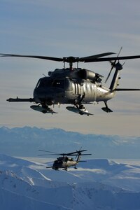 Two HH-60 Pave Hawk helicopters from the Alaska Air National Guard fly over Alaska during a training mission Feb. 18, 2011.