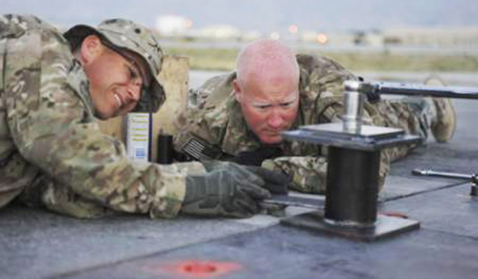 Maj. Ryan Kaspari, left, and Master Sgt. Jeremiah Graves conduct repairs on the main runway June 9, 2014, at Bagram Air Field, Afghanistan. Kaspari is the 455th Expeditionary Civil Engineer Squadron operations chief and Graves is the 455th ECES NCO in charge of operations. Both Airmen are deployed from the Air National Guard’s 148th Fighter Wing, Duluth, Minn. (U.S. Air Force photo/Airman 1st Class Bobby Cummings)