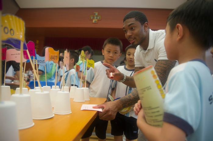HONG KONG (June 19, 2014) - Ship's Serviceman Seaman Normal Stoll, from East Orange, N.J., center-right, plays a game with Sham Tseng Catholic Primary School students during a community relations project hosted by the U.S. Navy's forward-deployed aircraft carrier USS George Washington (CVN 73). George Washington and its embarked air wing, Carrier Air Wing (CVW) 5, provide a combat-ready force that protects and defends the collective maritime interests of the U.S. and its allies and partners in the Indo-Asia-Pacific region. (U.S. Navy photo by Mass Communication Specialist 3rd Class Paolo Bayas)