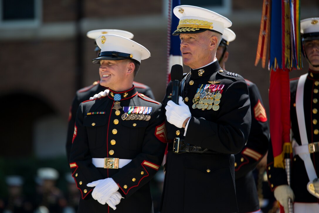 Cpl. Kyle Carpenter, Medal of Honor recipient, and Gen. James Amos, commandant of the Marine Corps, give a speech during a parade in Carptener's honor at Marine Barracks Washington, D.C., June 20, 2014. Carpenter is the third Marine to recieve the Medal of Honor since the beginning of Operations Iraqi Freedom and Enduring Freedom. (Official Marine Corps photo by Cpl. Larry Babilya/Released)