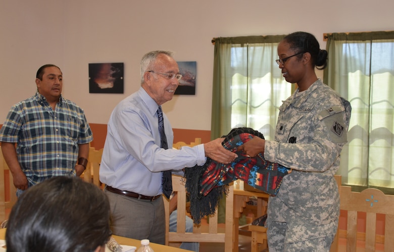 COCHITI PUEBLO, N.M., -- Cochiti Governor Joseph Suina presents Lt. Col. Gant with a blanket made by the family of one of the Tribal Council members. The June 5, 2014, Corps-Cochiti partnership meeting is the final one for Gant, who is departing the District June 26 for her next position at the Pentagon.