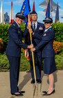Col. Virgina Garner, 15th Medical Group commander, left, hands the guidon to Lt. Col. Jennifer Vecchione, 15th Medical Operations Squadron commander, center, just prior to her taking command from Lt. Col. Michael Fea, right, in a ceremony at the Missing Man Formation on Joint Base Pearl Harbor-Hickam, Hawaii, June 20, 2014. (U.S. Air Force photo/Tech. Sgt. Terri Paden)