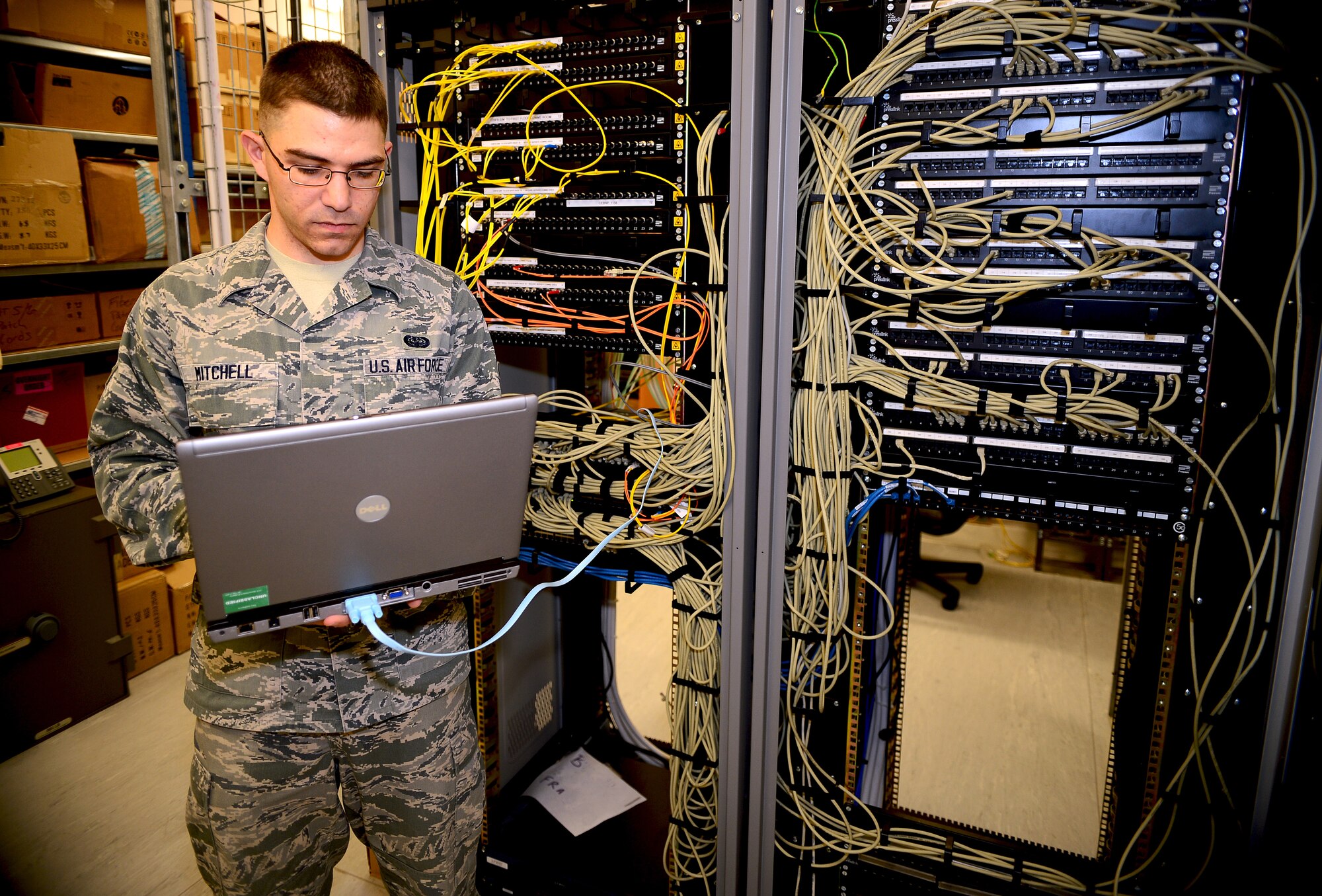 Airman 1st Class Kyle Mitchell, 48th Communications Squadron cyber transport technician, implements configuration changes to network components at Royal Air Force Lakenheath, England, June 18, 2014. Cyber transport Airmen manage, maintain and control devices that give Air Force computers the ability to send and receive information from local services, the Internet and other networks. (U.S. Air Force photo by Staff Sgt. Emerson Nuñez/Released)