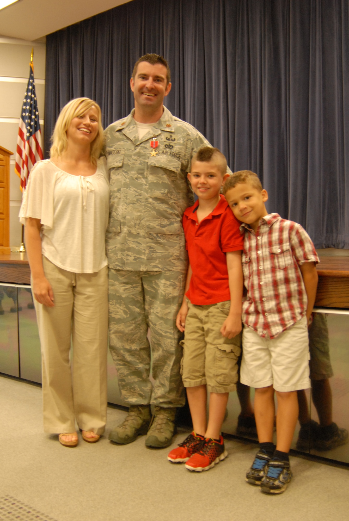 Air Force Maj. Devin Tomaseski, base civil engineer, 166th Civil Engineer Squadron, 166th Airlift Wing, Delaware ANG, with his fiancé, Christie Williams, his son, Xander, and stepson, Justin, after Tomaseski received the Bronze Star medal at a ceremony held at 166th AW HQ, New Castle ANG Base, New Castle, Del. on June 20, 2014. Tomaseski distinguished himself by exceptionally meritorious service while deployed in support of Operation Enduring Freedom in Afghanistan from 2011 to 2012. This is the third Bronze Star medal awarded to Tomaseski. (U.S. Air National Guard photo by Tech. Sgt. Benjamin Matwey)