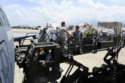 Two U. S. Air Force servicemembers from the 612th Air Base Squadron, Joint Task Force-Bravo, Soto Cano Air Base, Honduras, unload over 29,000 pounds of humanitarian aid and supplies from a U. S. Air Force KC-10 Extender bound for Honduran citizens in need June 6, 2014.  The supplies were sent to Honduras through the Denton Program, which allows private U.S. citizens and organizations to use space available on U.S. military cargo planes to transport humanitarian goods to approved countries in need.  (Photo by Martin Chahin)
