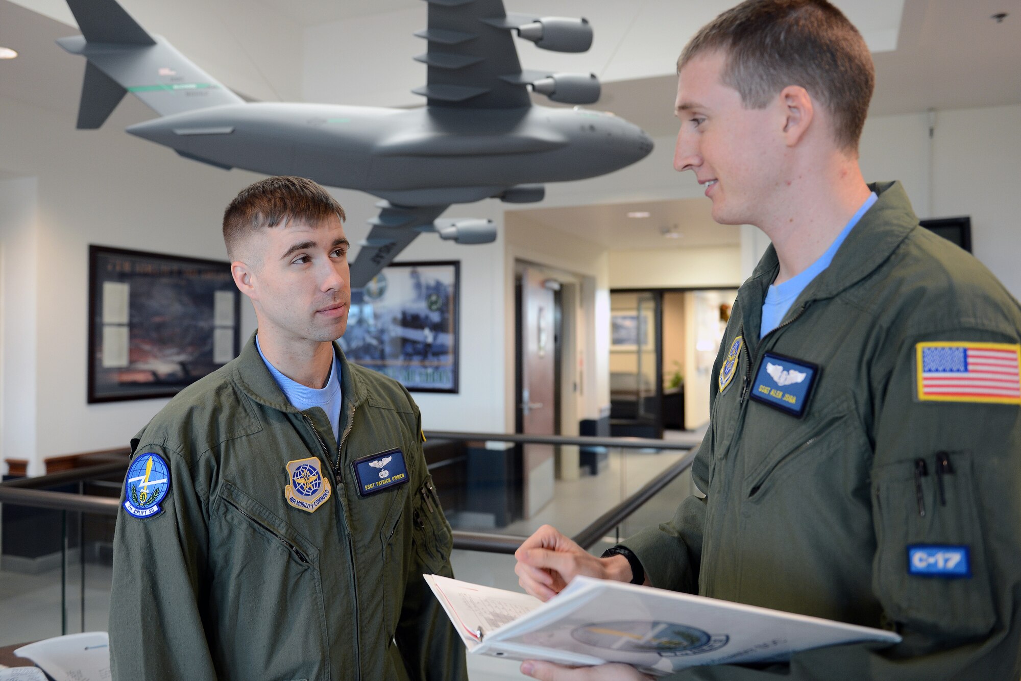 Wearing their morale Friday T-shirts, Staff Sgt. Alek Joga (right), 7th Airlift Squadron loadmaster, and Staff Sgt. Patrick O’Brien, 7th AS loadmaster, review training requirements together June 20, 2014, at Joint Base Lewis-McChord, Wash. Morale T-shirts are allowed to be worn by Airmen on Fridays or during special events as directed by squadron commanders. (U.S. Air Force photo/Airman 1st Class Jacob Jimenez)  