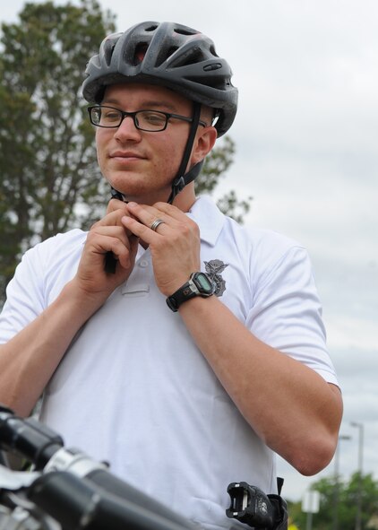 U.S. Air Force Airman 1st Class Paul Neese, 7th Security Forces Squadron patrolman, straps on his bicycle safety helmet June 9, 2014, at Dyess Air Force Base, Texas. Bike patrols offer more visible, constant and approachable presence because the Airmen can go places that are restricted to vehicles. (U.S. Air Force photo by Senior Airman Shannon Hall/Released)