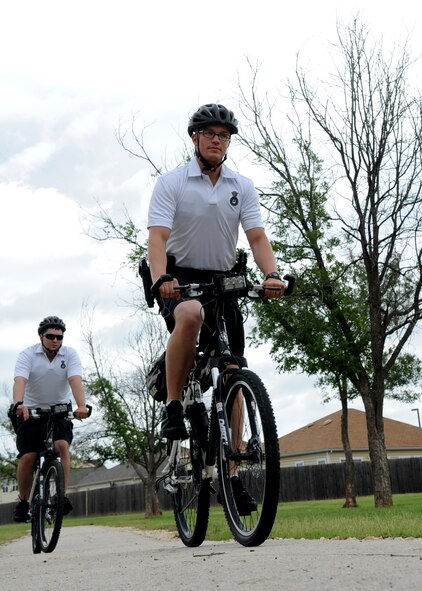 U.S. Air Force Senior Airman Enrique Martinez, left, and Airman 1st Class Paul Neese, 7th Security Forces Squadron, conduct bike patrols through Dyess base housing June 9, 2014, at Dyess Air Force Base, Texas. The patrols have added benefits outside of resident safety by helping the Airmen stay mentally and physically fit so they can accomplish the Dyess mission. (U.S. Air Force photo by Senior Airman Shannon Hall/Released)