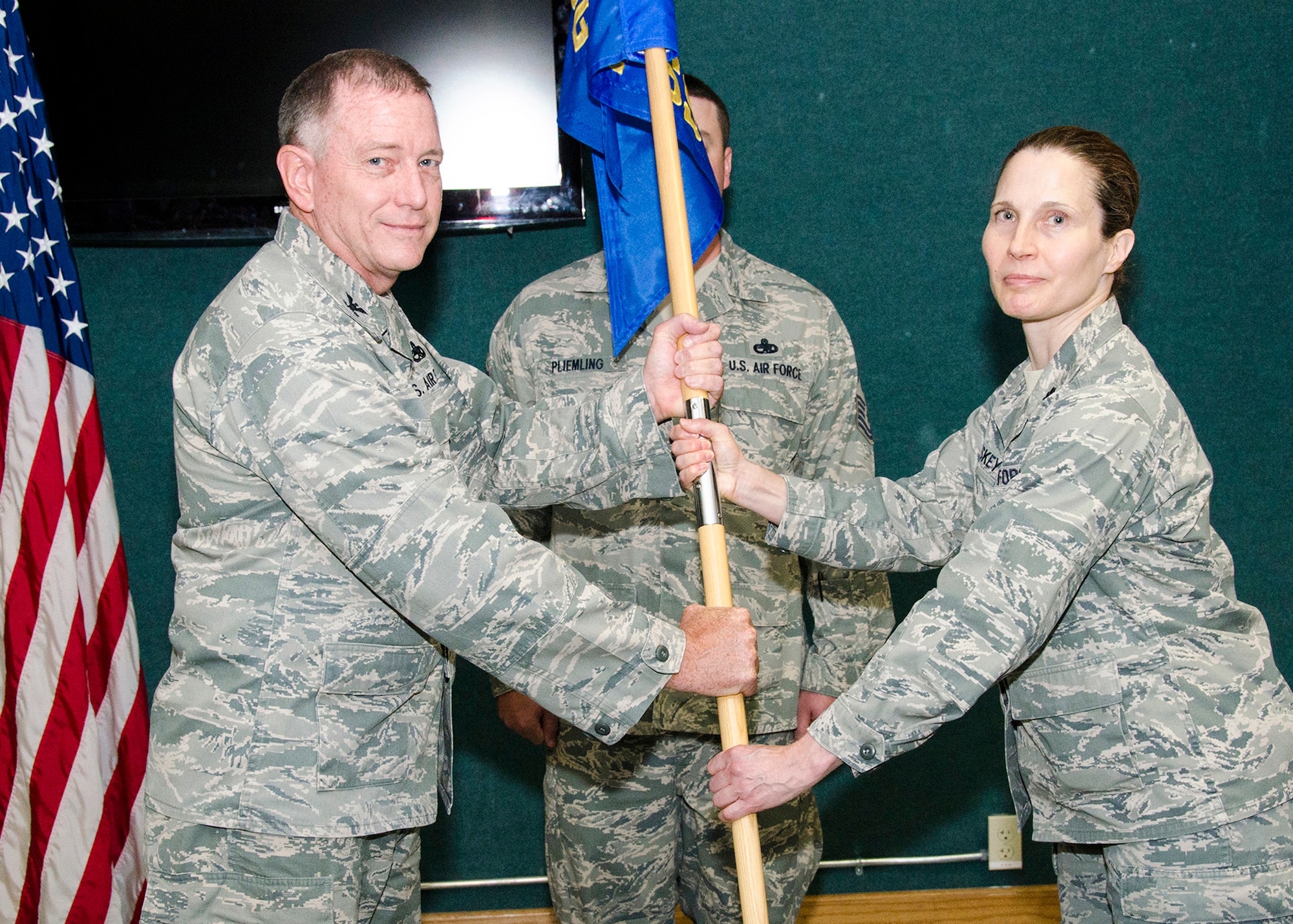 Lt Col. Catherine Sheskey, 131st Force Support Squadron commander, Missouri Air National Guard, accepts the 131st Bomb Wing guidon from Col. Mark Beck, 131st Bomb Wing Mission Support Group commander, during her assumption of command ceremony at Whiteman AFB, June 18, 2014. The guidon is a tradition that stems from ancient times and represents the unit and its commanding officer.  (U.S. Air National Guard photo by Airman Halley Burgess)