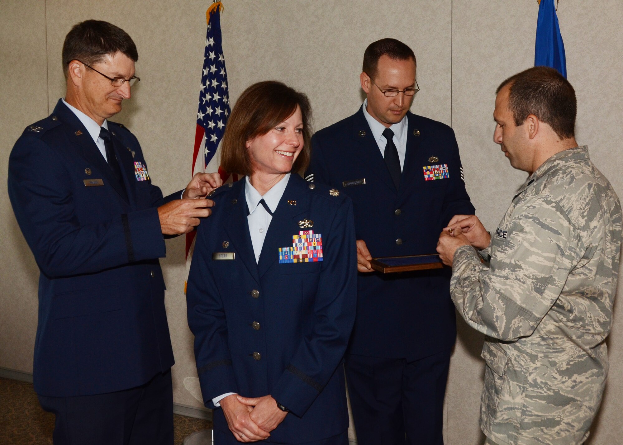 During a ceremony held at Whiteman AFB, June 10, 2014, Col. Kimbra Sterr's new silver eagles are pinned on by her spouse, Lt. Col Chad Sterr, and 131st Bomb Wing Missouri Air National Guard wing commander, Col. Mike Francis. Sterr is the 131st Maintenance Group commander.   (U.S. Air National Guard photo by Senior Master Sgt. Mary-Dale Amison)