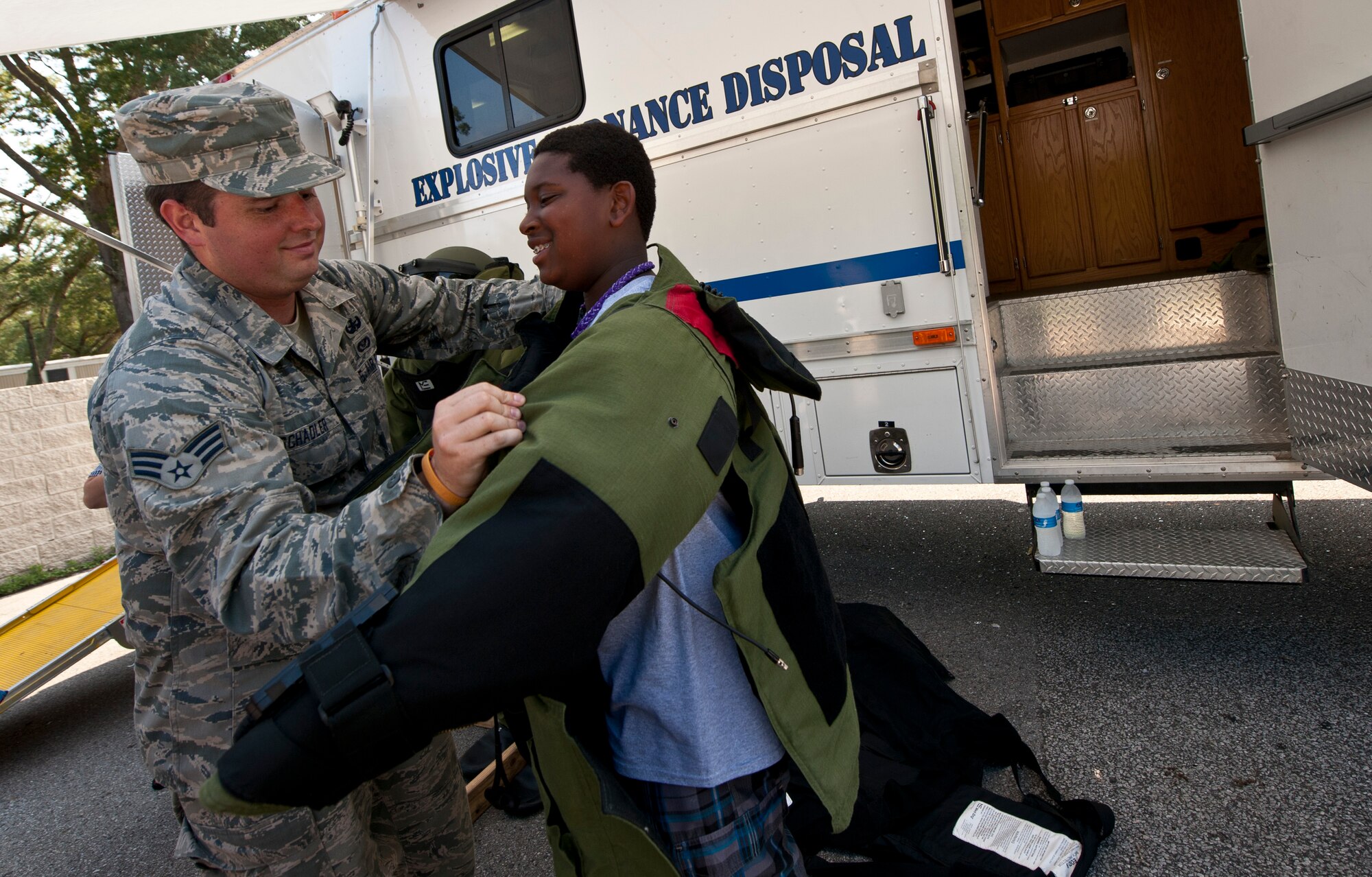 Senior Airman Eric Schabler, 1st Special Operations Civil Engineer Squadron explosive ordnance disposal journeyman, helps a student don a bomb suit during the Okaloosa County Sheriff’s Office youth week at the fairgrounds in Niceville, Fla., June 20, 2014. During the event, Schabler assisted kids with the bomb suit and explained its purpose. (U.S. Air Force photo/Senior Airman Krystal M. Garrett) 