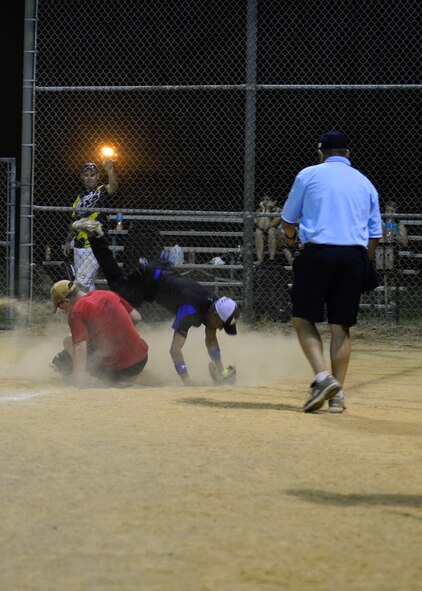 Curtis Thomas, 436th Security Forces Squadron catcher, is taken off his feet by a slide from Kyle Heathington, 436th Aerial Port Squadron coach-left fielder, during an intramural softball game June 18, 2014, at the softball field on Dover Air Force Base, Del. Thomas made the out and the 436th SFS defeated the 436th APS, 11-8. (U.S. Air Force photo/Airman 1st Class William Johnson)