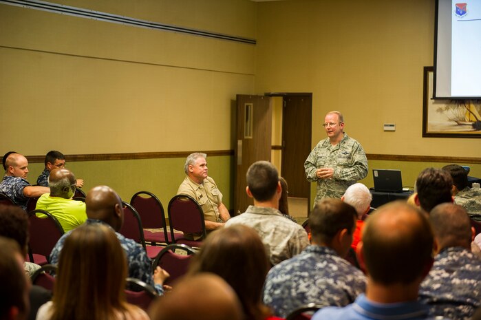 Col. Jeffrey DeVore, Joint Base Charleston commander, discusses base topics with the crowd at a commander's call, June 19, 2014, at Joint Base Charleston, S.C. Base leadership answered questions from the audience and talked about the future of JB Charleston. (U.S. Air Force photo/Senior Airman George Goslin)