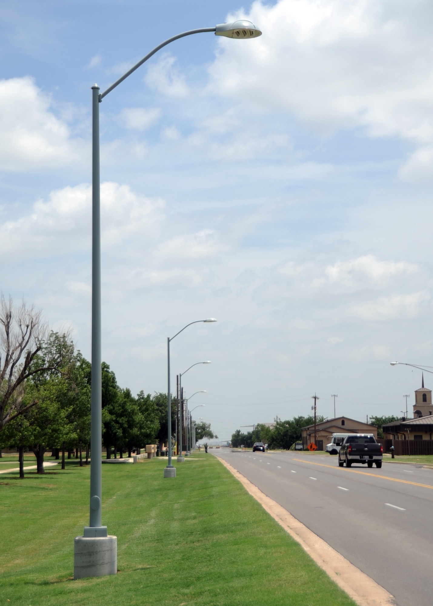 ALTUS AIR FORCE BASE, Okla. – The 97th Air Mobility Wing’s new streetlights on F Avenue stand without visible power lines attached, June 18, 2014. New street lights are being put up since the ones that were attached to the above ground power lines have been removed. The base is replacing the above ground power lines to underground which will reduce damages from weather and wildlife. (U.S. Air Force photo by Senior Airman Franklin R. Ramos/Released)