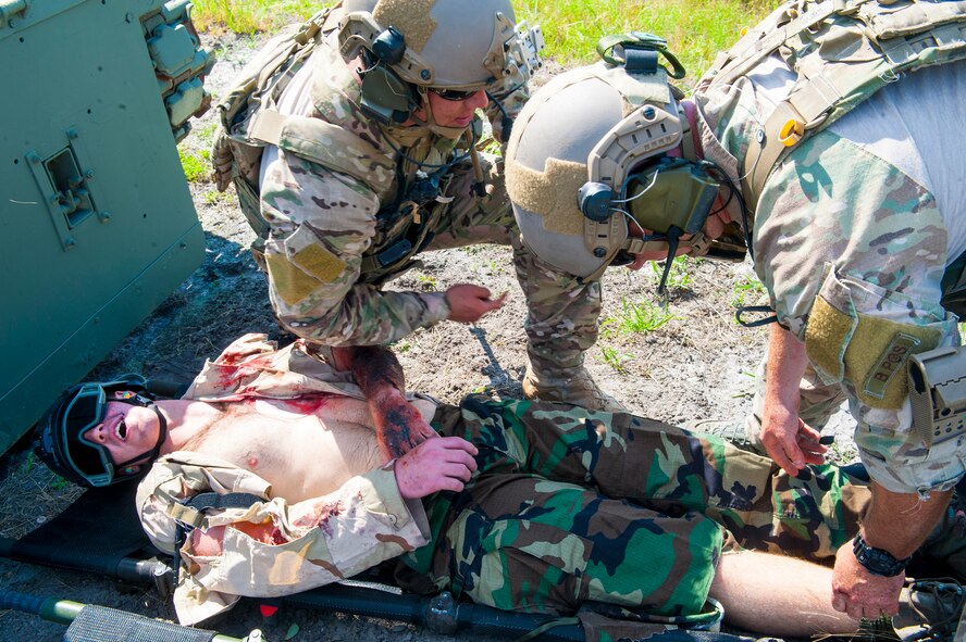 Pararescuemen from the 38th Rescue Squadron, treat a victim during a combat search and rescue training exercise at Moody Air Force Base, Ga., June 18, 2014. Moody’s pararescuemen treated the victim and transported him to a nearby helicopter where he was airlifted to a simulated hospital. (U.S. Air Force photo by Airman 1st Class Ceaira Tinsley/Released)