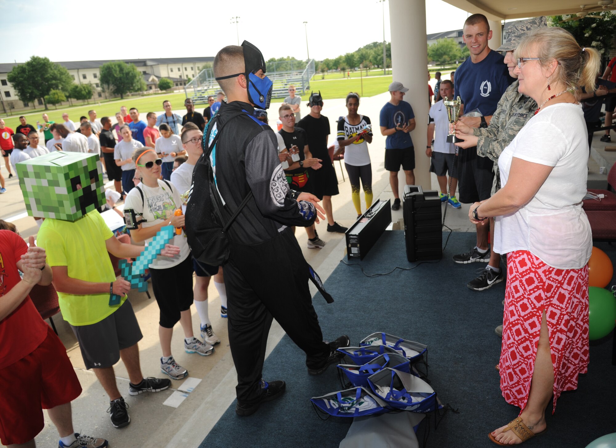 Airman Basic Antonio Casillas, 338th Training Squadron student and teal rope member, accepts his trophy for best costume as “Sub-Zero” during a 5K run hosted by the 81st Training Group teal rope program June 19, 2014, at the Triangle, Keesler Air Force Base, Miss. The super hero themed event raised more than $1,300 for the Gulf Coast Women’s Shelter for Non-Violence.  (U.S. Air Force photo by Kemberly Groue)