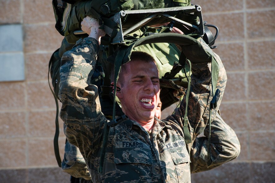 U.S. Air Force Cadet Phillip Fekaris performs squats while holding a ruck sack above his head at Moody Air Force Base, Ga., June 17, 2014. Fekaris visited Moody as part of the combat rescue officer (CRO) shadow and orientation week, a program designed to give interested cadets a glimpse of the physical training requirements to become a CRO. (U.S. Air Force photo by Airman 1st Class Ryan Callaghan/Released)
