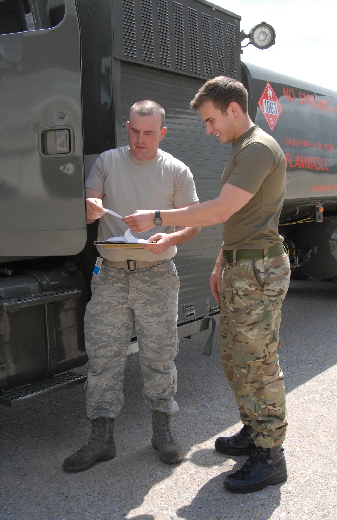 Senior Airman Zachery Conoway (left), 193rd Logistics Readiness Squadron Refueling Flight, completes a fuel verification receipt for Senior Aircraftsman David Fox, a member of Great Britain's Royal Air Force 33 Engineer Squadron. RAF troops and aircraft arrived at the 193rd Special Operations Wing recently to participate in the Keystone Forge bilateral training exercise and to conduct proficiency flying in the area. (U.S. Air National Guard photo by Staff Sgt. Susan Penning/Released)