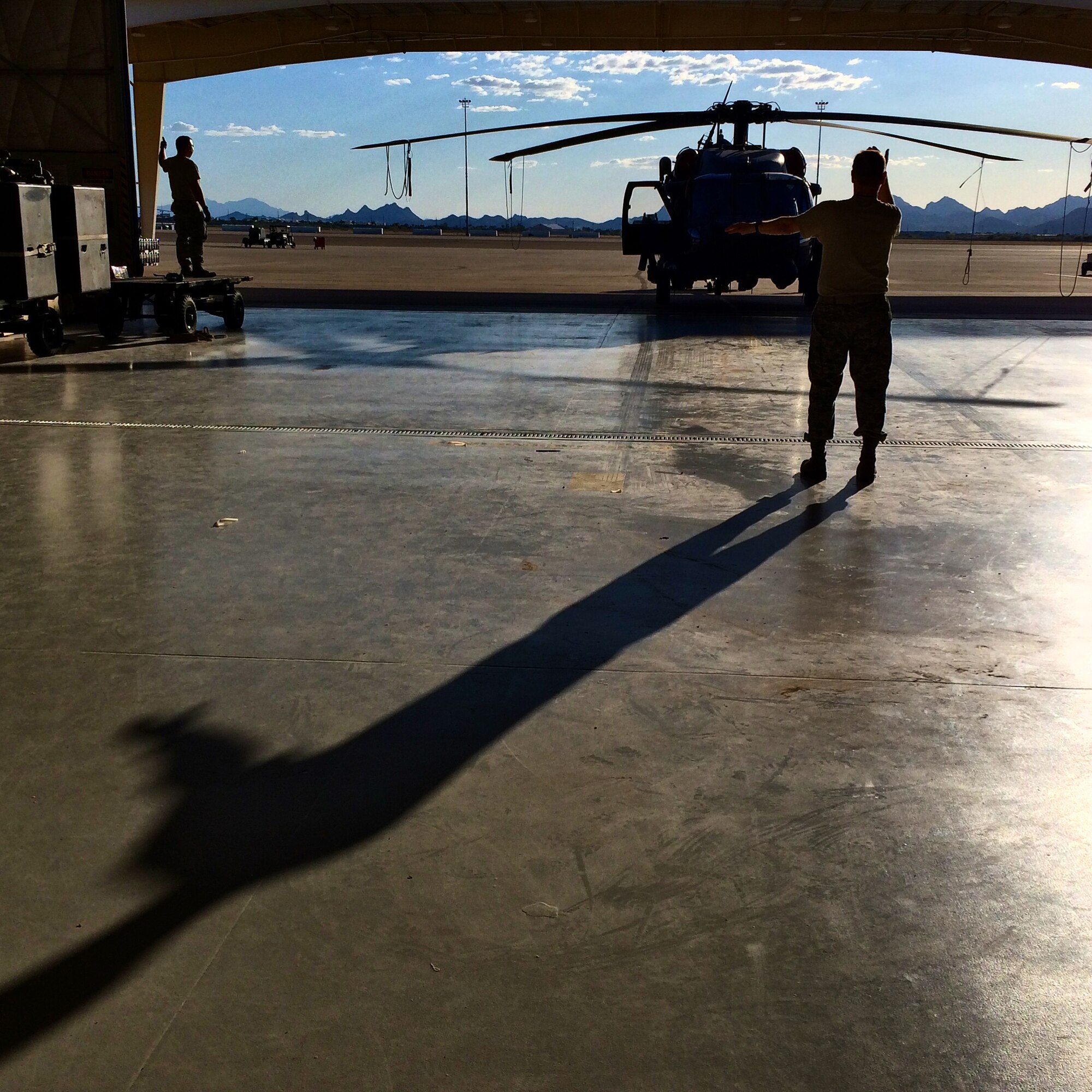 Tech Sgt. Peter Muntean guides an HH-60G Pave Hawk helicopter into a hangar at Davis-Monthan Air Force Base, Ariz., June 19, 2014. (U.S. Air Force photo/2nd Lt. Anna-Marie Wyant)